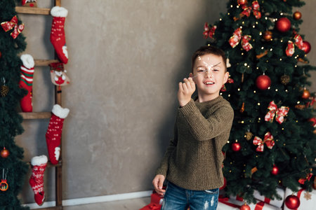Boy with sparkler at christmas treeの写真素材