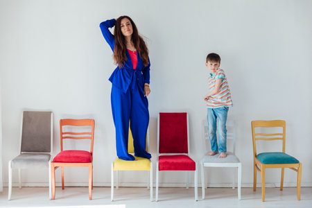 Woman with boy and many different chairsの写真素材