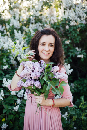 woman with a bouquet of lilacs on a walk nature flowersの写真素材