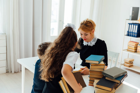 teacher and children schoolchildren in the library with booksの写真素材