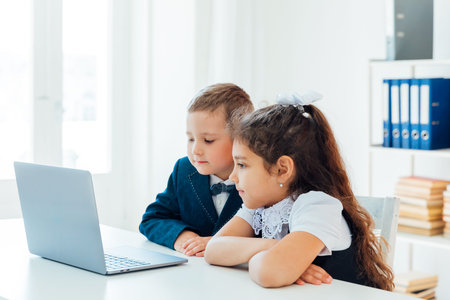 Boy and girl studying at a table with a laptopの写真素材