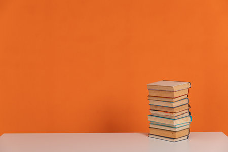 vintage stacks of books to read on an orange backgroundの写真素材