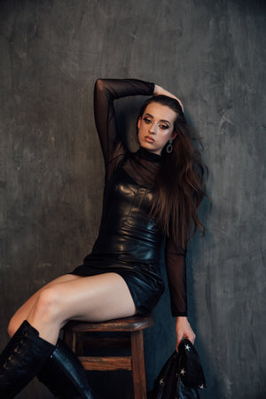 Beautiful slim woman in black leather dressの写真素材