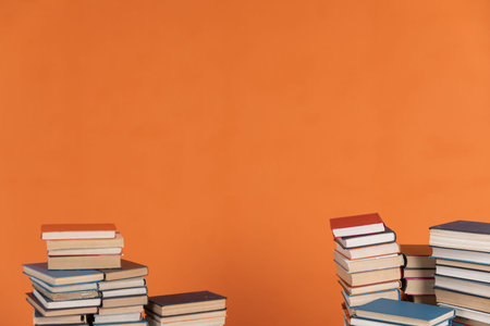 vintage stacks of books to read on an orange backgroundの写真素材