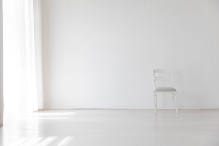 old vintage white chair in the interior of a white room by the windowの写真素材