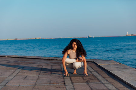 woman doing gymnastics yoga asana by the sea