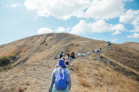 Tourists travelers climb to the top of the mountainの写真素材