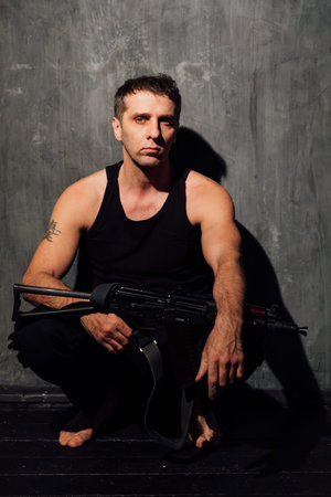 man in a black top with a gun