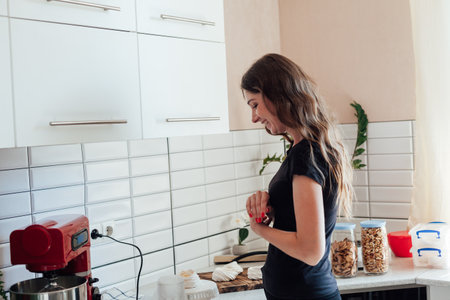 Woman cooking pastry cakes in the kitchenの写真素材