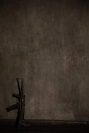 Assault Rifle Stands Against Dark Wall As Background