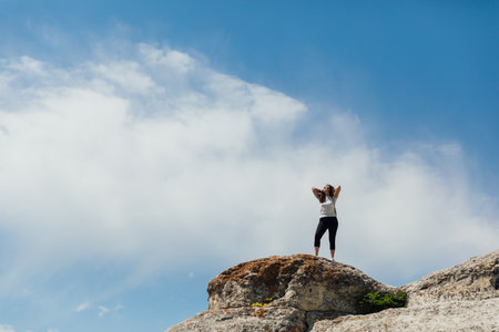 Female looking at the view from the top of the mountain on a hikeの写真素材