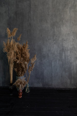 Baskets with dried flowers in a dark gray room interiorの写真素材