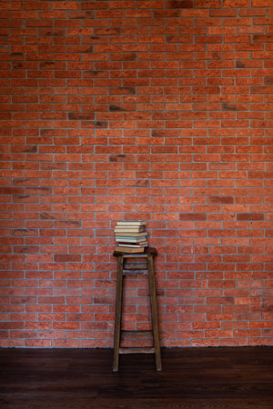 Wooden Chair and Stack of Books by Brick Wallの写真素材