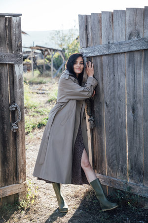 Beautiful fashionable brunette woman in gray coat at the doorの写真素材