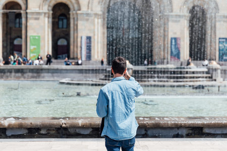 man stands with his back and looks at the fountain