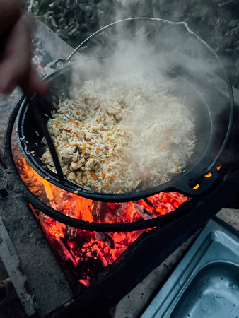 Cooking rice with vegetables on fireの写真素材