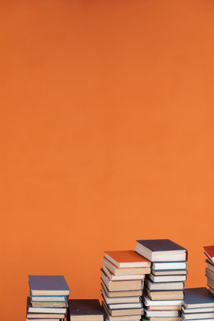 Stacks of old books on an orange university backgroundの写真素材
