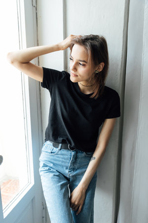 Brunette woman posing while leaning against a doorの写真素材
