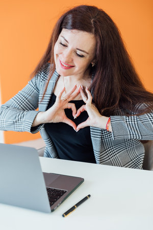 Brunette Business Woman Showing Her Hands Heart In Office Onlineの写真素材