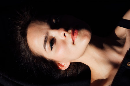 Slim brunette woman in black lingerie lying in bedroom on bed before going to bedの写真素材