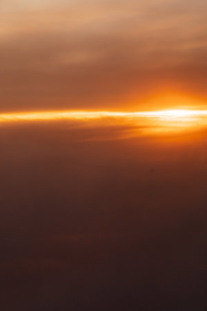 Beautiful landscape on the sunset sky with clouds from the airplane windowの写真素材