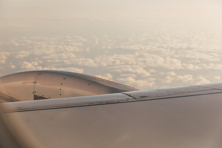 A wing of a passenger plane and cloudsの写真素材