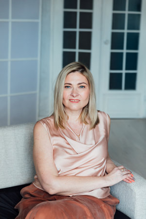 Businesswoman sitting on sofa in white officeの写真素材