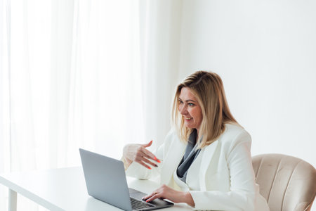 Woman in business suit working with online laptop in officeの写真素材