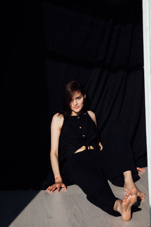fashion woman in black clothes sitting on the floorの写真素材
