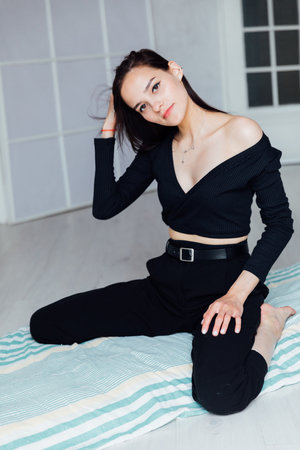fashion woman in black clothes sitting on the floorの写真素材