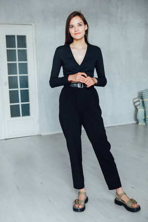 Portrait of a beautiful slender young brunette girl in black clothesの写真素材