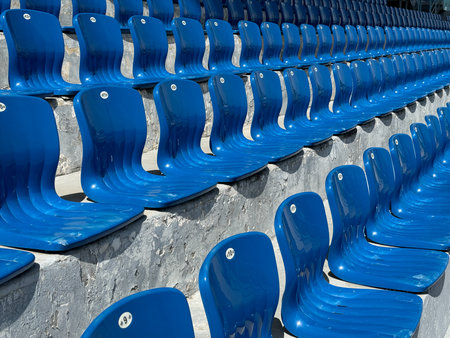 lots of blue plastic seats for spectators in the stadiumの写真素材