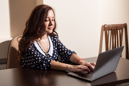 woman working on laptop at desk in officeの写真素材