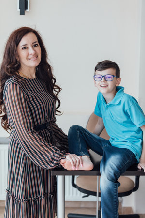 Brunette mom hugging her son with glassesの写真素材