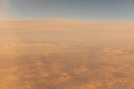 Beautiful landscape on the sunset sky with clouds from the airplane windowの写真素材