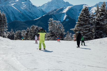 Snowboarders and skiers ski in the ski resort on the slopes