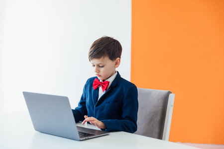 Boy In Business Suit And Tie Working On Laptop Online