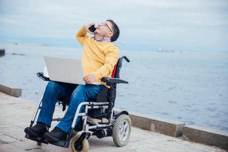 man on a wheelchair uses smartphone