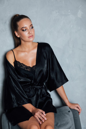 Portrait of a beautiful fashionable woman in a black silk robeの写真素材