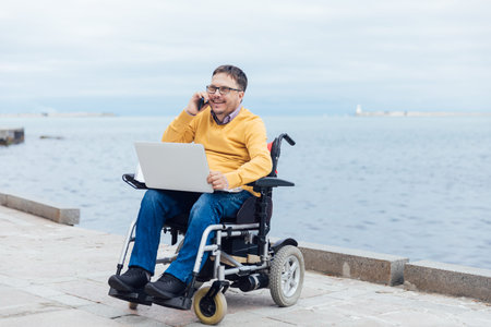 disabled businessman on a wheelchair at a window uses smartphone 4k