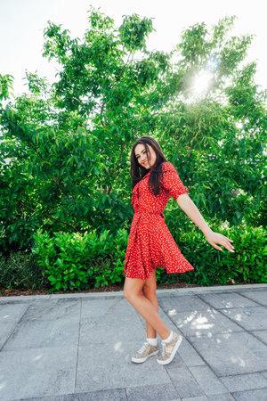 women in a polka dot dress smiling on the streetの写真素材