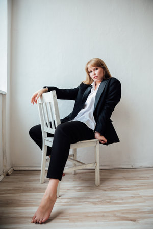 Portrait of a beautiful young fashionable woman in a black suitの写真素材