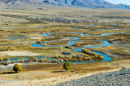 Top view of the Altay Russian village of Ortolyk, the steppe and Altai mountains, the winding Chuya river, Siberia, Russia.の写真素材
