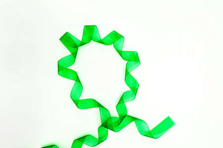 Green ribbon with swirls around the circle, isolated on a white background, ornament.の写真素材