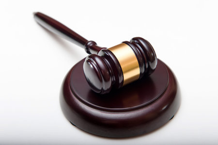 Wooden judges hammer with a metal ring and soundboard isolated on a white background with...