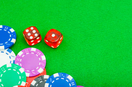 close-up poker chips and dice on the green baize table with copy spaceの写真素材