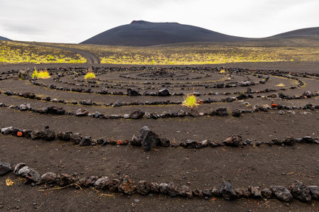 Esoteric place of power-a spiral made of stones against the background of a volcanic hill,...