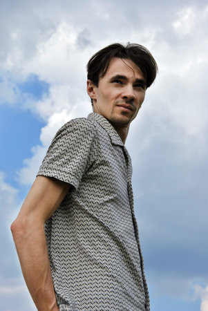 nice man against the blue sky looks into the distance