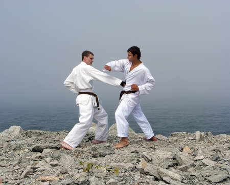 two karateka fight on the banks of the misty seaの写真素材