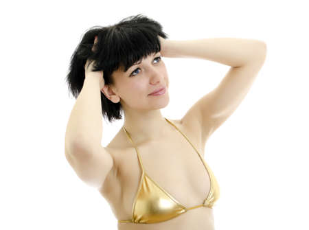 Brunette girl posing in golden underwear. Isolated on white background.の写真素材